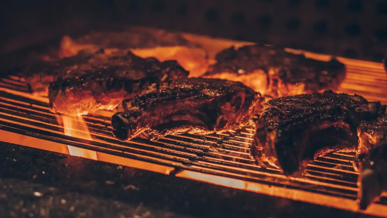 Chuletas haciéndose en la parrilla sobre las brasas