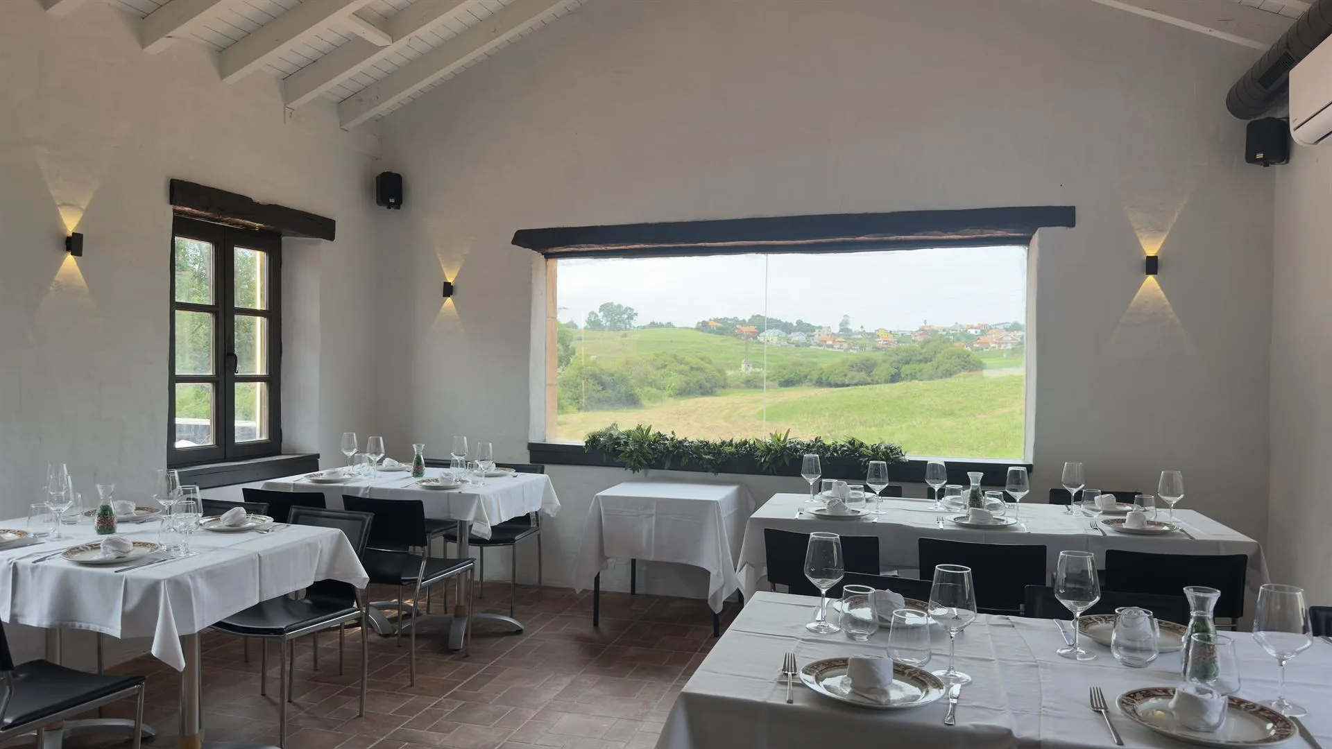 Comedor de Las Teresitas con el ventanal abierto a la campiña de Suances